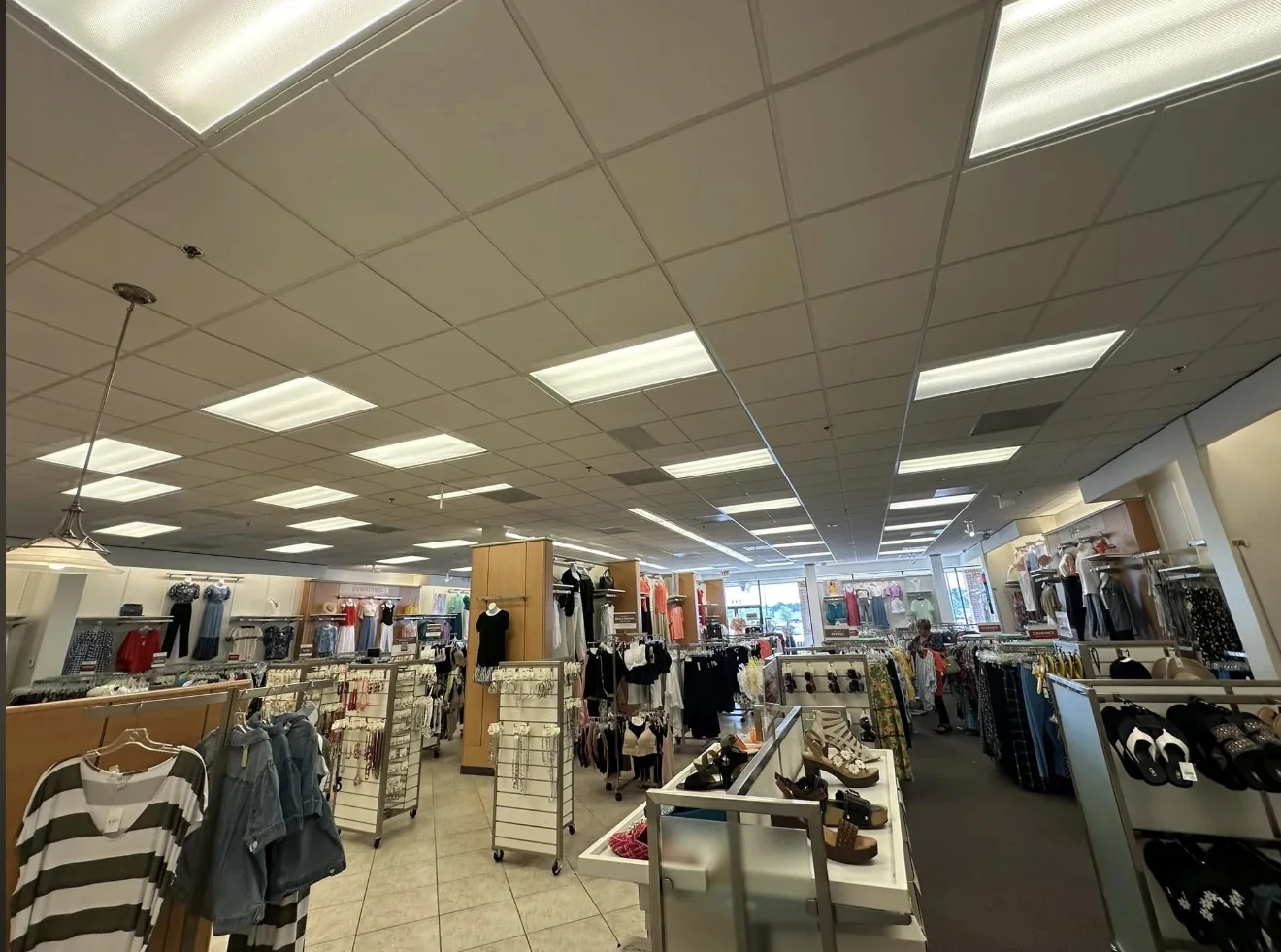 Illuminated ceiling fixtures across a clothing retail interior